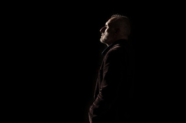 Adult man in suit on street in winter with sunlight and shadow