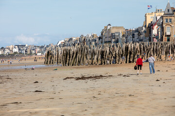  Romantic walk of people on the picturesque beach of Saint Malo. Brittany, France