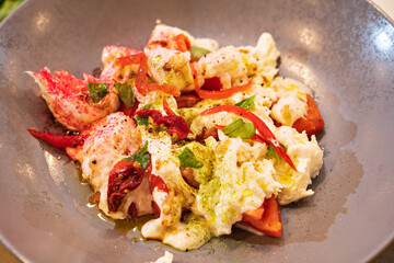 salad with crabs on a gray plate. seafood dish. menu in the restaurant.