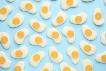 Tasty jelly candies in shape of egg on light blue background, flat lay