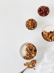 Yogurt, granola and nuts, breakfast on a light table. View from above. Copy space.