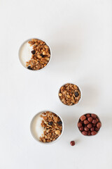 Yogurt, granola and nuts, breakfast on a light table. View from above. Copy space.