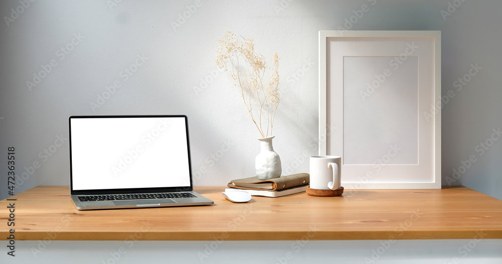 Wall mural mock up laptop computer with empty screen, coffee cup and notebook on wooden table.