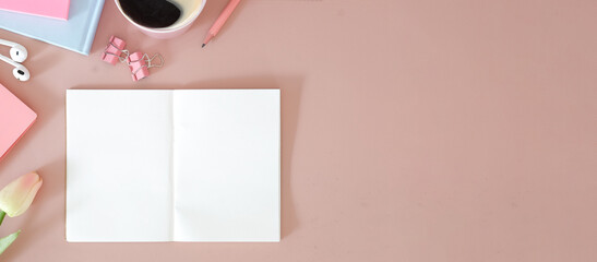 Empty notebook, coffee cup and tulips on pink background.