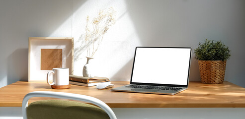 Modern workplace, computer laptop and supplies on wood table.