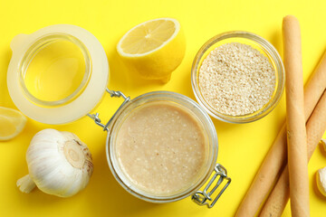 Concept of tasty food with tahini sauce on yellow background
