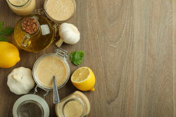 Concept of tasty food with tahini sauce on wooden background