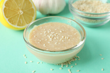 Concept of tasty food with tahini sauce on mint background