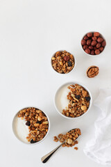 Breakfast is on the table. Granola with raisins and nuts, yoghurt. Copy space, top view.