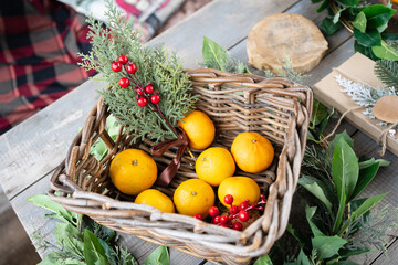 basket with tangerines and coniferous branches. table setting