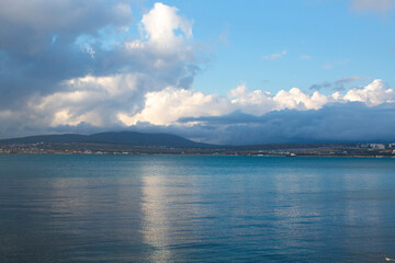 A blue cloud with a white cloud is reflected in the sea