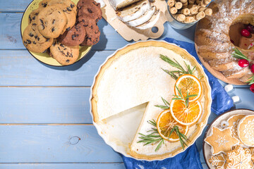 Homemade Christmas pastries, sweet cheesecake pie with powdered sugar, orange and rosemary. Christmas  and New Years festive baking background