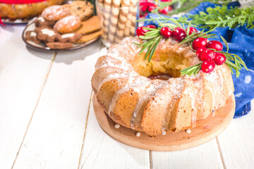 Homemade Christmas pastries, sweet fruitcake pie with powdered sugar, cranberries and rosemary. Christmas  and New Years festive baking background