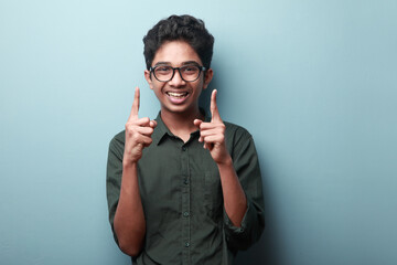 Portrait of an excited boy of Indian ethnicity showing hand gesture