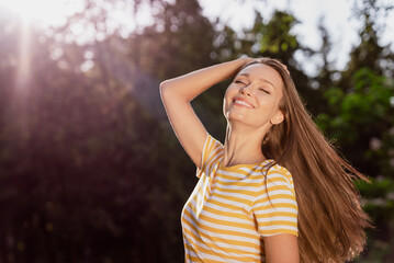 Fototapeta premium Portrait of attractive carefree cheerful dreamy peaceful girl spending holiday free time posing breathing fresh air outdoors