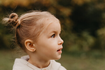 portrait of a little cute girl walking in the autumn park