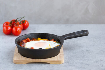 Baked egg with vegetables in a skillet