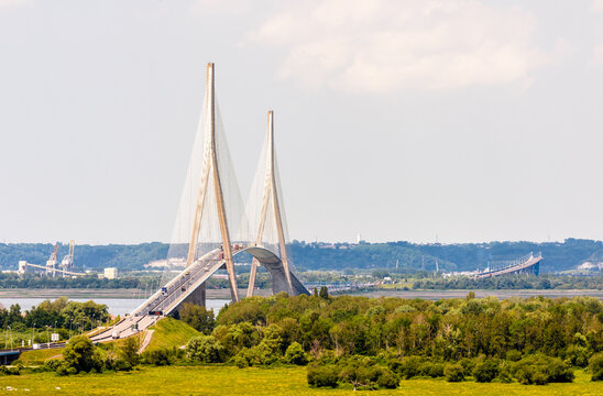 Ablon, France - June 16, 2021: General view of the Normandy bridge, a cable-stayed road bridge over the Seine river, seen from the left bank with the Pont sur le Grand Canal du Havre in the distance.
