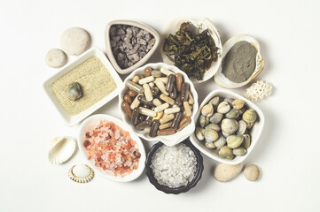 Dietary supplements in capsules, various crystals of salt, algae and sea minerals in plates