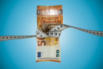 50 Euro Schein von Bandmaß zusammengebunden, Inflation, Rezession