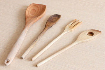 Three wooden spoons and one wooden fork on a table - 472374175