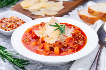 Minestrone soup with cavatappi pasta, beans and vegetables with crispy bread, horizontal, closeup