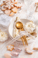 Fototapeta na wymiar Place setting and Christmas table decorated with ornaments, gingerbread and cookies