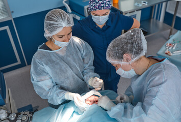 Close up of the face of a patient who is undergoing blepharoplasty. The surgeon cuts the eyelid and...