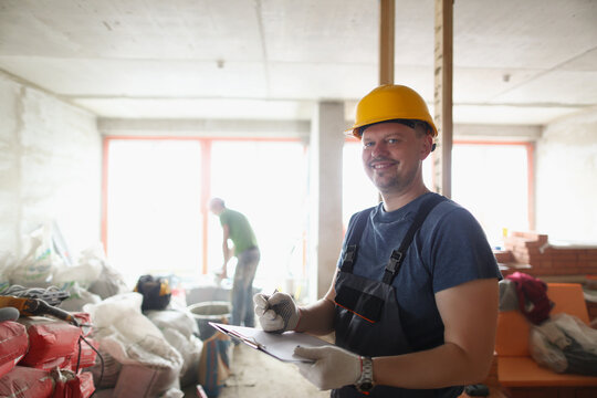 Smiling professional worker hold clipboard and list work materials