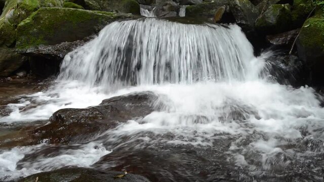 岩の段差を落ちて飛沫を上げる川の流れ