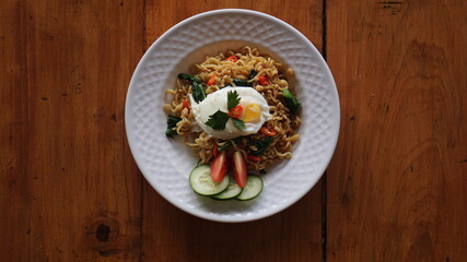 A plate of fried noodles with sunny side up eggs