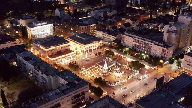 Podgorica Montenegro at night - town square in the city center decorated and illuminated. Lights in downtown area within urban residential neighborhood. Aerial drone view of the buildings.