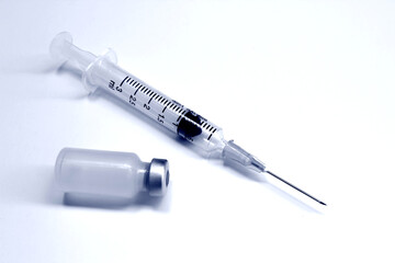Vial of drugs or vaccine and 3 ml plastic syringe with needle isolated on the white background, blue tone color