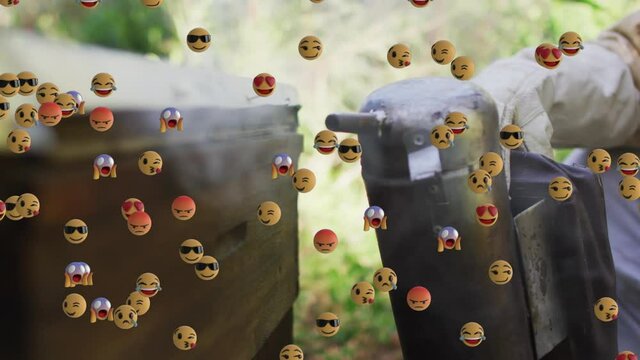 Animation of emojis floating over beekeeper smoking beehive
