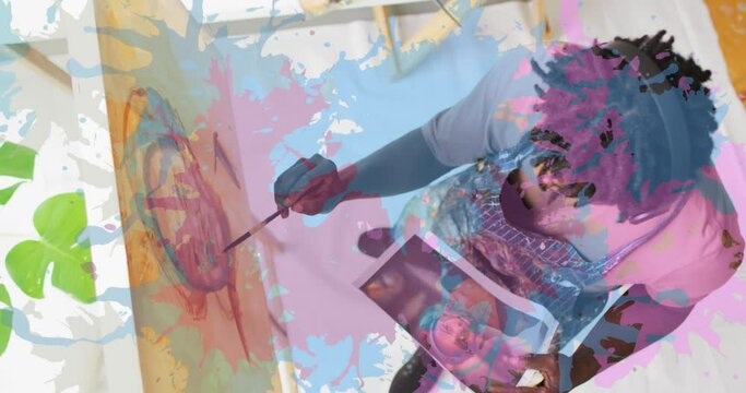 Animation of pink and blue paint over artist painting picture