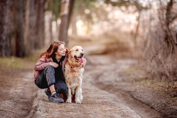 Girl with golden retriever dog in the wood