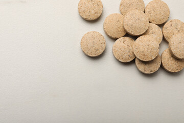Dietary supplement pills on white table, flat lay. Space for text