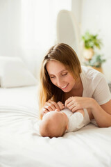 Happy young mother with her newborn baby at home.