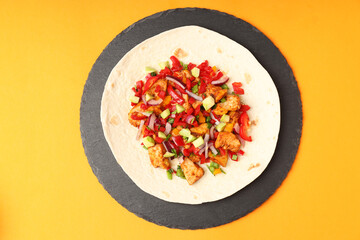 Tasty taco on board on orange background