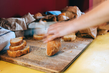 waiter cutting bread in the restaurant - hands on the go chopping food on the table
