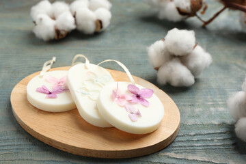 Scented sachets and cotton flowers on blue wooden table