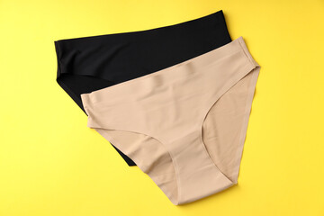 Concept of women's clothes with panties on yellow background