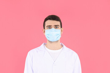 Doctor - intern in mask on pink background