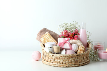 Obraz na płótnie Canvas Concept of gift with basket of cosmetics on white table