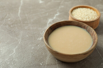 Concept of tasty food with tahini sauce on beige textured background