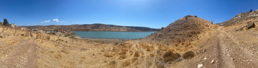 panorama photo background, view of the abandoned Turkish village of Finikas with the ruins of houses on the banks of the reservoir in Cyprus, Paphos