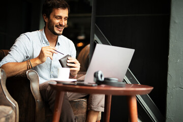 Handsome businessman working on laptop and sitting in cafe. Young student learning online.