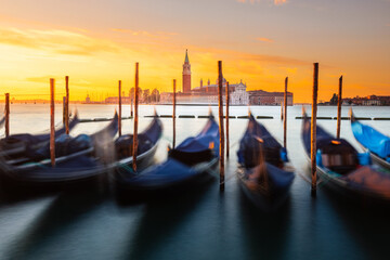 Gondolas parked at Venezia with San Giorgio Maggiore church at the back while sunrise, Veneto, Italy..