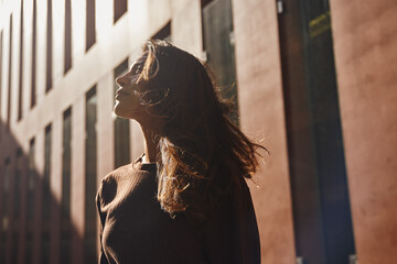 Young businesswoman standing against new building