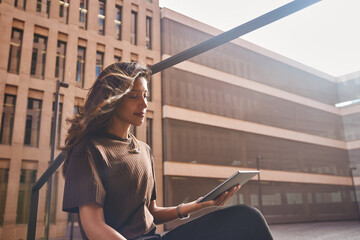 Young businesswoman sitting and using tablet